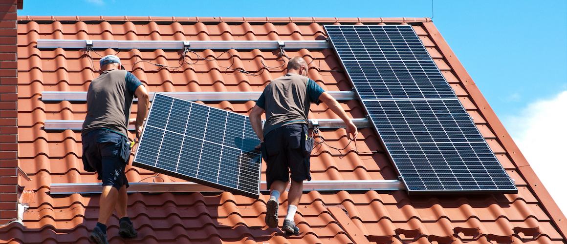 Fachkräfte installieren Solarmodule auf einem Dach